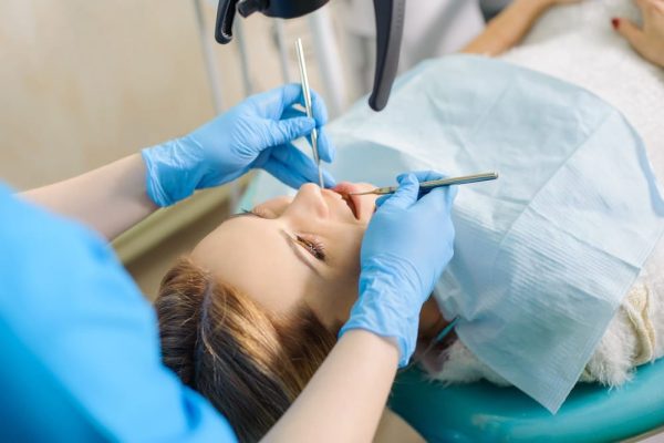 female-dentist-treating-caries-using-microscope-at-2023-11-27-04-52-37-utc (1)