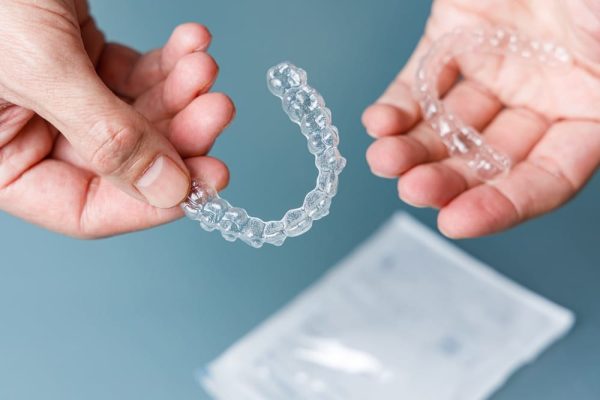 hands-holding-transparent-aligners-invisalign-ort-2023-02-28-18-33-53-utc (1)