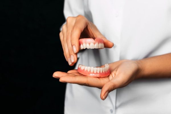 the-dentist-is-holding-dentures-in-his-hands-dent-2023-11-27-05-03-51-utc (1)