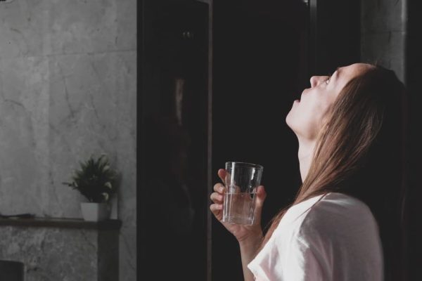 young woman rinses her mouth with water while look 2021 08 29 01 24 05 utc