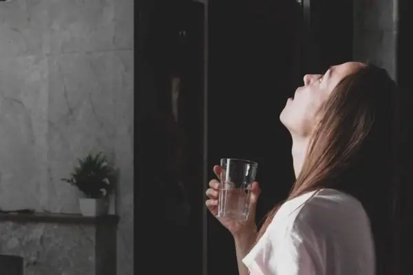 young woman rinses her mouth with water while look 2021 08 29 01 24 05 utc